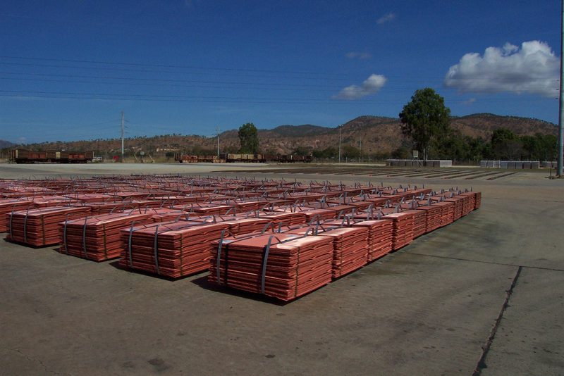 Des paquets de cathodes de cuivre empilés sur un parc, prêts à être expédiés