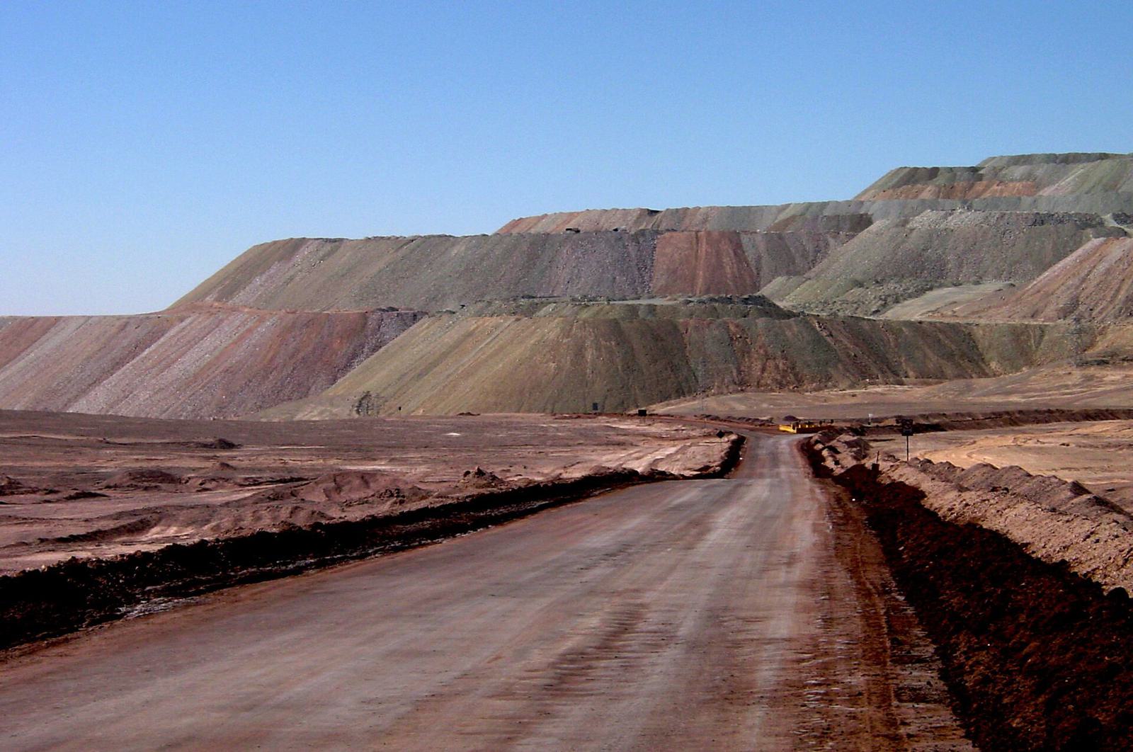 A dirt haul road running between huge waste dumps in the desert